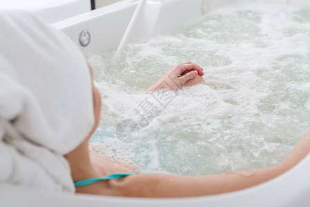 在温泉沙龙洗浴时放松头部用毛巾露出女图片