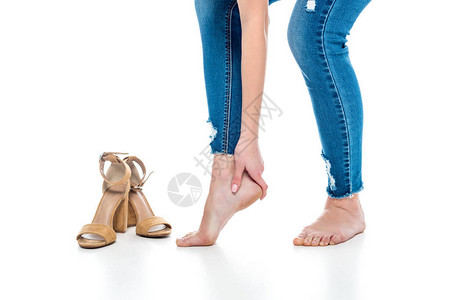 赤脚的疲累妇女站近高跟鞋图片