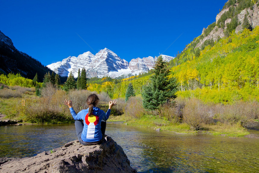 一个女孩在秋天科罗拉多州白杨的栗色钟声中沉思图片