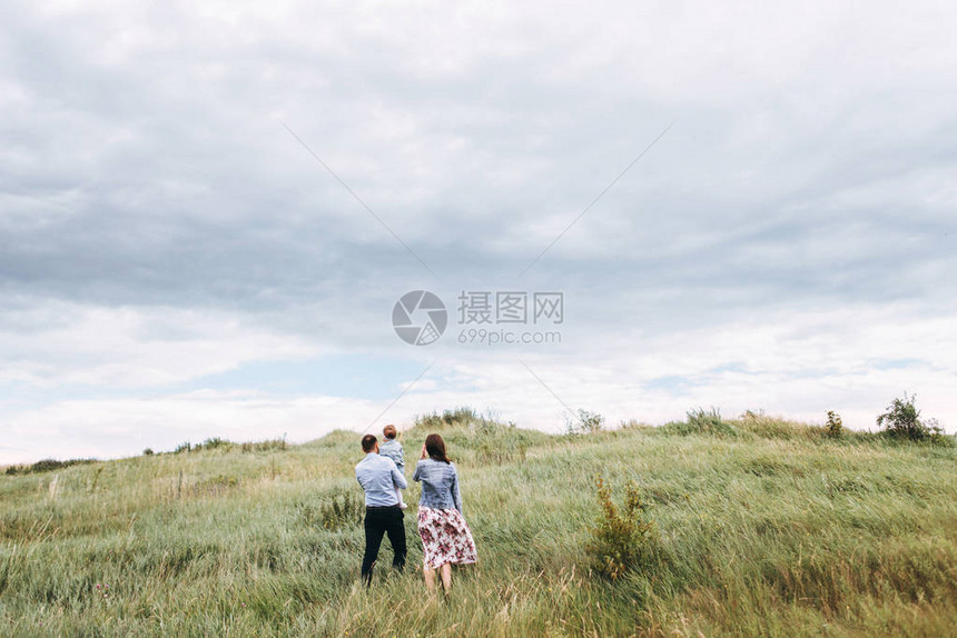 在风灰日带小孩在草地上行图片