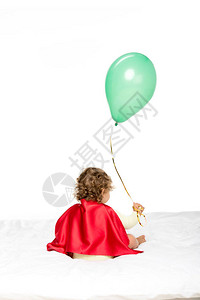 在超级英雄披风中可爱的小孩带着白色孤立图片