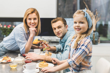 父母和小女儿在家一起吃早饭并图片