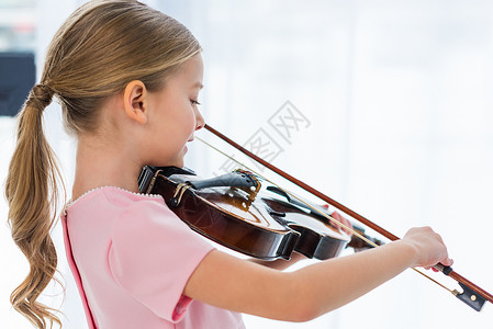 穿粉红裙子在家里拉小提琴的小提琴的可图片