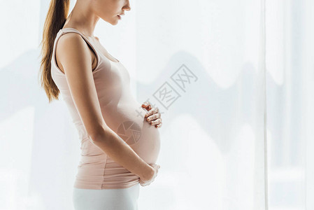 孕妇在家里摸肚子的剪影图片