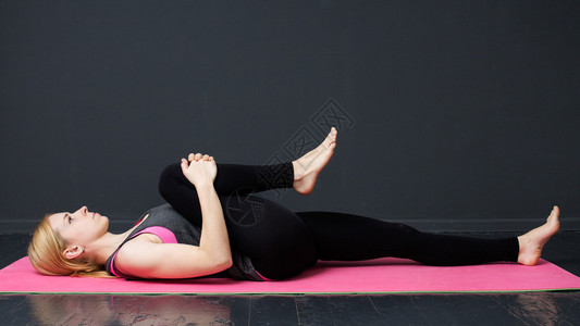 瑜伽健身年轻女子正在垫子上做瑜伽锻炼图片