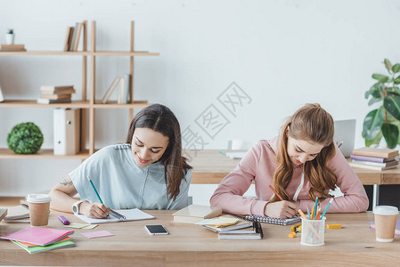 多族裔女学生一起写考试成绩的女生和背景图片