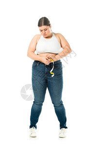 穿着牛仔裤测量腰围的超重女心烦意乱图片