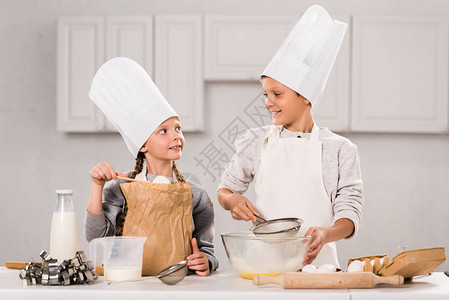 穿着围裙和厨帽的幼儿在厨图片
