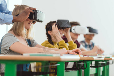 制作的非洲美籍教师对虚拟现实耳机进行校内同学坐在后面的少女学生调图片