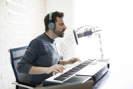 以耳机弹钢琴唱到麦克风在网上电台节目中唱歌的latinma图片