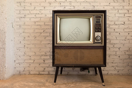 复古白墙背景中的复古旧电视背景图片