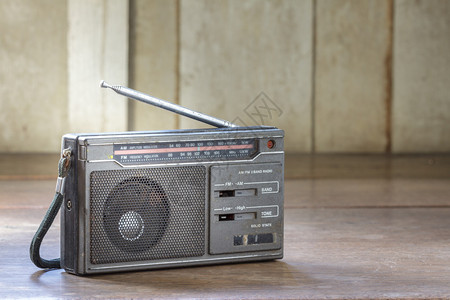木制背景上的旧晶体管收音机背景图片