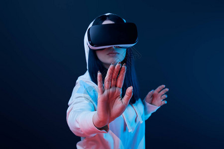 使用虚拟现实耳机的蓝色妇女有选择地聚焦于在蓝灯图片