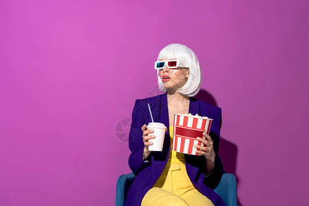 穿着3D眼镜的受惊女人坐在椅子上拿着苏打水图片