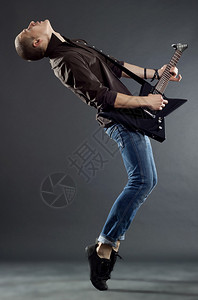 热情的吉他手用脚尖弹吉他背景图片