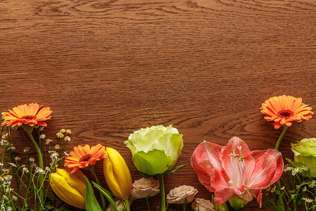 木制背景上盛开的五颜六色的春天花朵的顶视图图片
