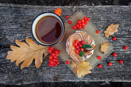 浪漫的秋天仍然有生命有篮子蛋糕茶杯罗兰浆果和叶子在木板图片