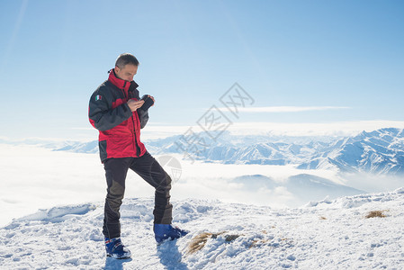 登山者在山顶上手持电话图片