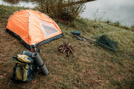 旅游帐篷背包带湖的乡村钓鱼竿图片