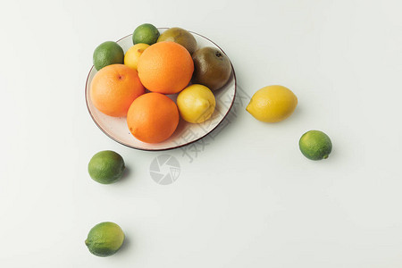 在白色背景上分离的盘子上的柑橘类水果图片