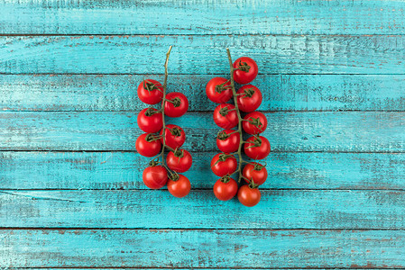 绿松石木桌面纹理上的樱桃番茄新鲜时令蔬菜概念背景图片