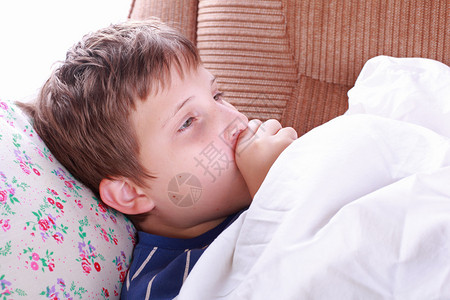生病的小孩在床上咳嗽高清图片