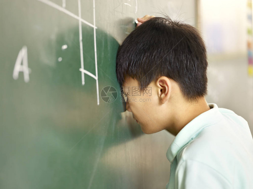 痛苦的亚洲小学生在解决几何问题时图片