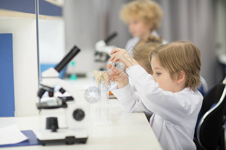 小男孩调整科学实验室的空背景图片