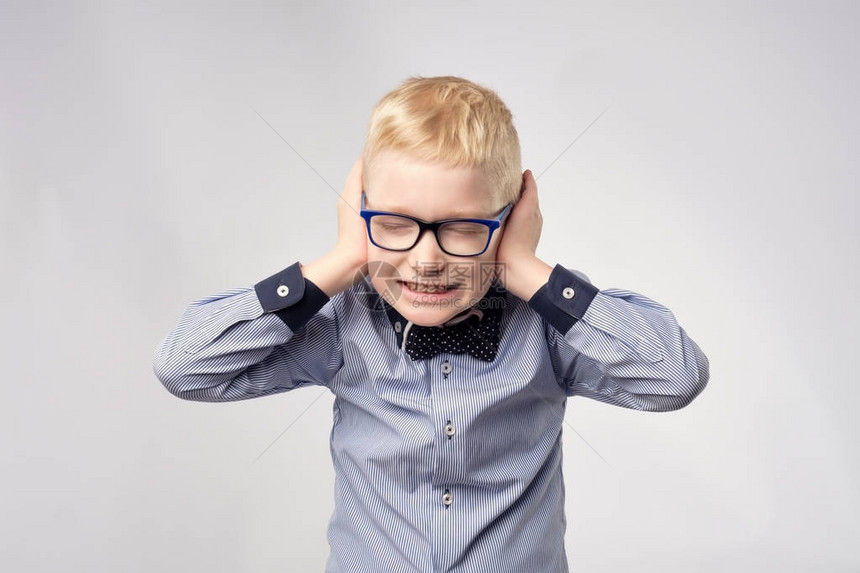 隔绝的男高音男孩用双手遮住耳朵的肖像图片