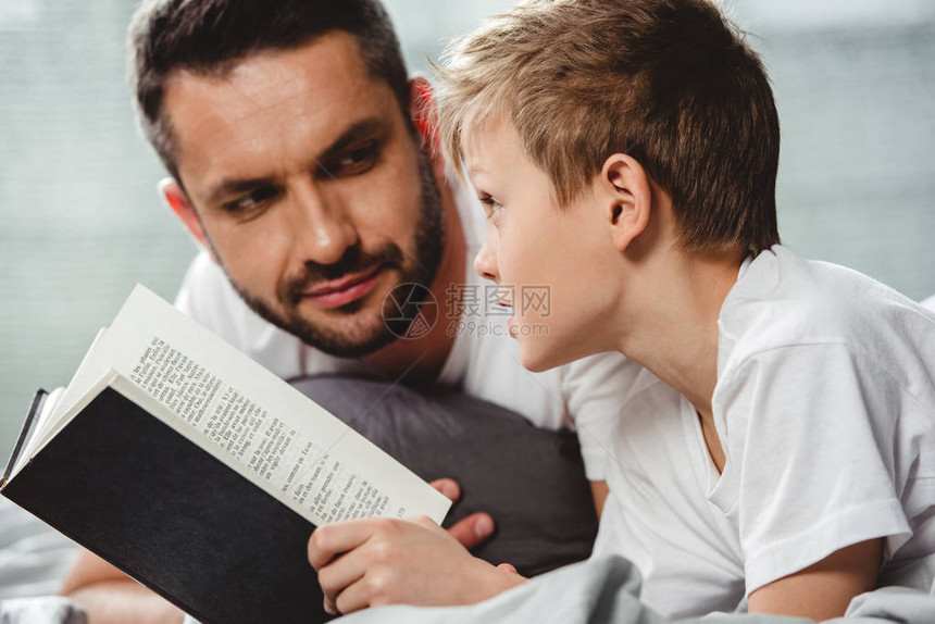 父亲和儿子在床上阅读图片