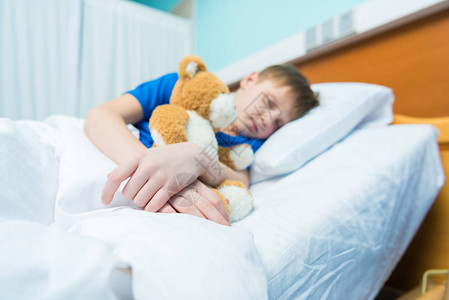 生病的小男孩睡在医院的床上图片