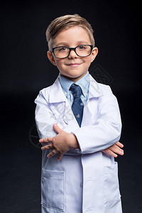 眼镜和实验室外套中的小男孩科学家在镜图片