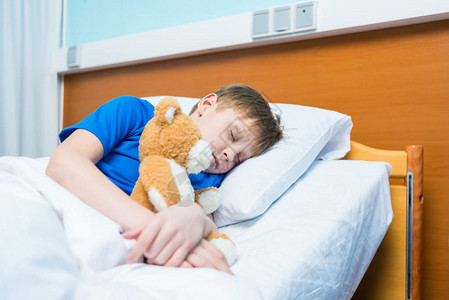 生病的小男孩睡在医院的床上图片