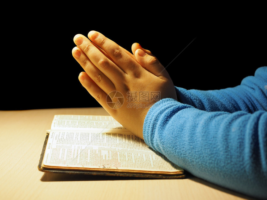 一个拿着圣经祈祷的孩子图片