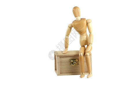 坐在宝箱上的木制人体模型图片