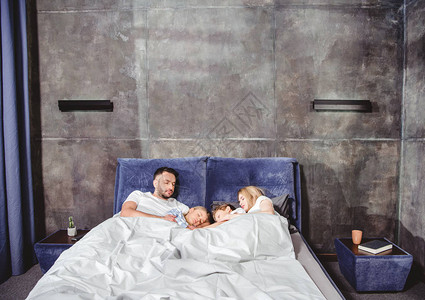 幸福的一家人躺在床上睡在图片