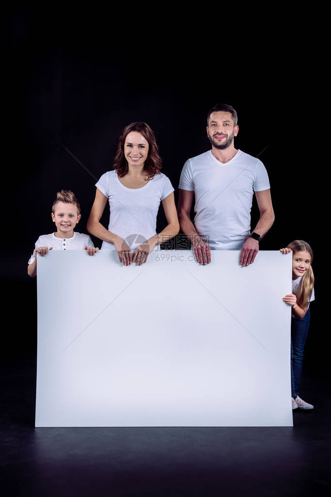 微笑的家庭站在白卡上看着被黑色图片