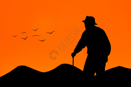 老人在日落时行走山图片