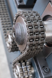 三连串滚链围绕工业机器上的三个螺图片