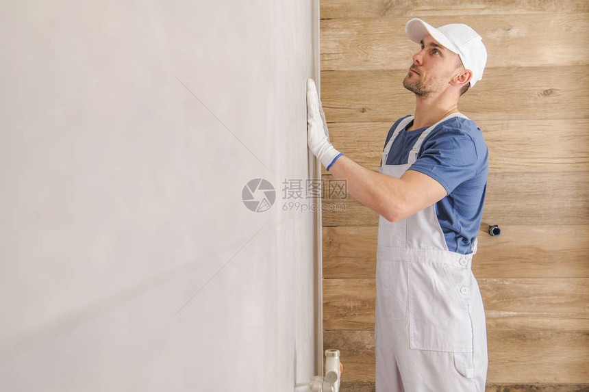 陶瓷砖墙壁完工白种人瓷砖安装器正在检查浴室内图片