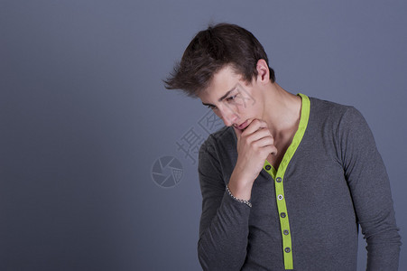 一个忧郁的年轻男子灰色背图片