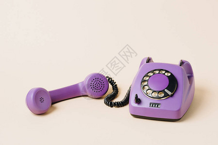 紫色反向旋转电话在米背景图片
