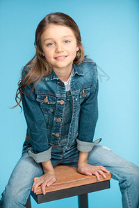 小女孩的肖像微笑和坐在凳子上图片