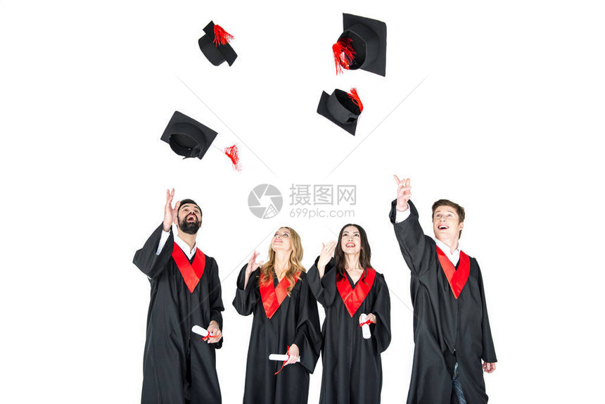 带着毕业证书的快乐年轻学生们扔着孤立在白图片