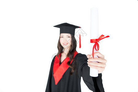 穿着毕业礼服持有孤立的白衣文凭的微背景图片