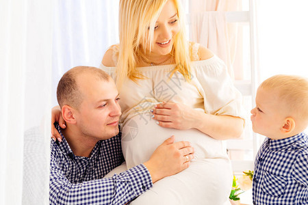 怀孕的妻子和她的丈夫把手放在她的肚子上图片