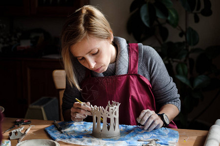 在陶器厂制造陶瓷树成品的妇女陶器匠图片