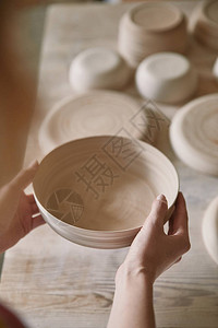 陶艺工作室女手持陶瓷盘图片