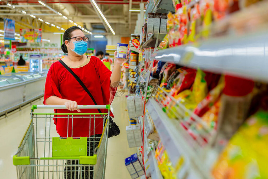 大流行期间戴着防护面具购物的妇女紧急购买清单食品和物资短缺疫情期间的防护措施为大流图片