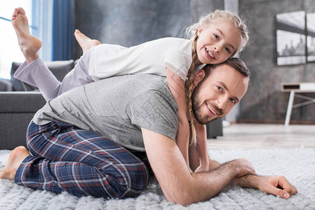 快乐的父亲和女儿在家里一起玩乐图片